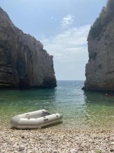 a boat sitting on a rocky beach next to the water at Holiday home Stiniva in Vis