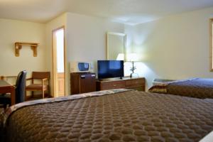 una camera d'albergo con letto e TV di The Otter Lodge a Ottertail