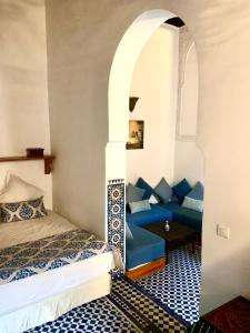 een kamer met een bed en een blauwe bank bij Riad Dar Pierre in Fès