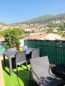 a table and chairs on a balcony with a view at Les Jardins des Senteurs - Appartement privé avec piscine et parking in Grasse