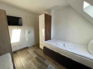 um pequeno quarto com 2 camas e uma televisão em Grüner Baum em Langenbrand