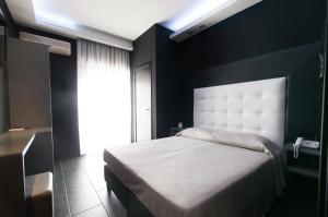 um quarto com uma cama com uma parede preta em Fly Boutique Hotel em Nápoles
