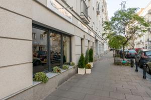 a street with a store window with potted plants at Poznanska Serviced Apartments in Warsaw