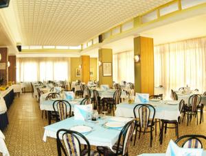 加提歐馬里的住宿－Hotel Welt，一间设有白色桌椅的用餐室