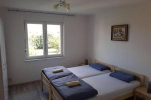 two twin beds in a room with a window at Apartman Valentic in Vinkovci