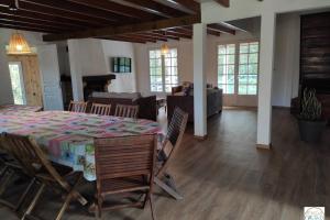 Zimmer mit einem Tisch und Stühlen sowie einem Wohnzimmer in der Unterkunft La Villa Des O, sentier Grand Bassin in La Plaine des Cafres