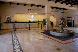 a lobby with a fountain in the middle of a building at Costa de Oro Beach Hotel in Mazatlán