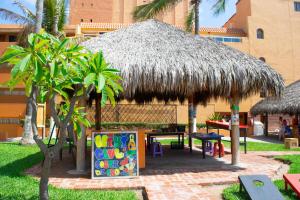 Costa de Oro Beach Hotel في مازاتلان: كوخ مع طاولة نزهة وطاولة مع علامة
