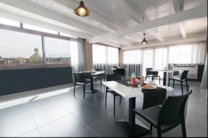 um restaurante com mesas e cadeiras e uma grande janela em Fly Boutique Hotel em Nápoles