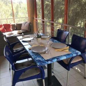 a table on a balcony with a table and chairs at Homoki Wellness Üdülőház in Balatonakarattya
