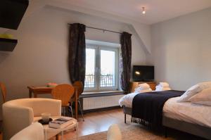 um quarto com uma cama, uma secretária e uma janela em Tresor Barska Apartments 2.0 em Cracóvia