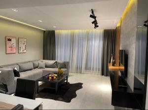 a living room with a couch and a table at بنتهاوس ميدتاون ممنوع الزيارات للعزاب in Cairo