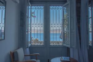 Zimmer mit einer Tür und Blick auf das Wasser in der Unterkunft ONOS RESIDENCE in Hydra