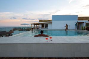 a man sitting in a pool with two glasses of wine at May Altafulla Beach Boutique Hotel in Altafulla