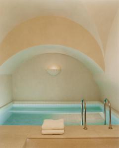 - une salle de bains avec une piscine d'eau et 2 serviettes dans l'établissement Château Voltaire, à Paris