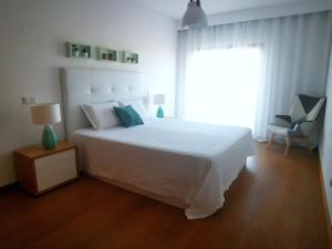 a bedroom with a white bed and a window at Terraços do Rio in Portimão +23 photos