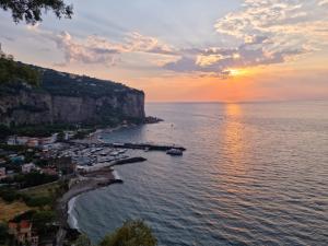 a sunset over a beach with boats in the water at casa anna in Vico Equense