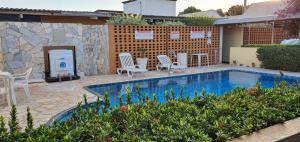 a patio with a pool and chairs and a fireplace at Hotel Urubupunga in Ilha Solteira