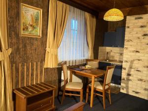 kuchnia ze stołem i krzesłami oraz oknem w obiekcie Penzion Aurooms w mieście Zlatníky