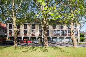 un edificio con árboles delante de él en Hotel Drei Morgen, en Leinfelden-Echterdingen