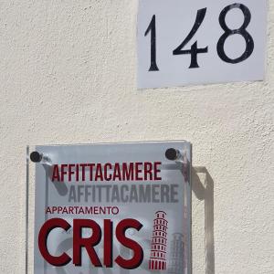 a sign on the side of a building with the number at rooms cris in Pisa