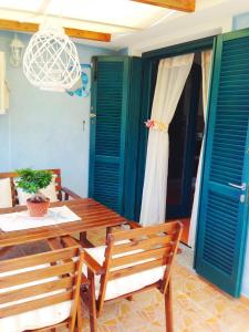 a patio with a wooden table and chairs and doors at Sardegna Costa Nord Ovest in Santa Maria