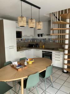 cocina con mesa de madera y sillas en Gîte la bassurelle Classé trois étoiles en Étaples