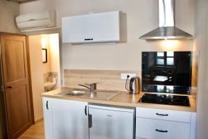 a small kitchen with a sink and a stove at Le Logis de Stofflet in Maulévrier