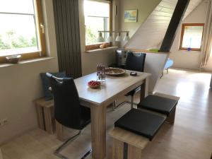 eine Küche und ein Esszimmer mit Tisch und Stühlen in der Unterkunft Ferienwohnung am Rohrbacherhof Sabine Rück in Barackenhöfe