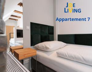 ein Schlafzimmer mit 2 Betten und ein Schild, das das Apartment liest in der Unterkunft Living inStein in Krems an der Donau