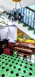 sala de estar con piano y sofá rojo en La Decima Guest House, en Chihuahua