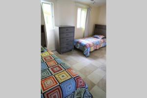 1 dormitorio con 2 camas y vestidor en A Beautiful villa in a prime location of Jolly en Jolly Harbour