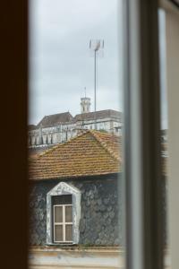 Avenida Central - Coimbra Accommodation في كويمبرا: مبنى بحائط حجري ونافذة