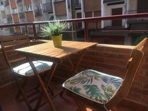 - Balcón con mesa de madera y 2 sillas en Egia Plaza en San Sebastián