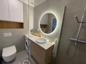 une salle de bain avec un lavabo, des toilettes et un miroir dans l'établissement Nadmorska ucieczka Niechorze - Niechorze Seaside Getaway - Rezydencja Niechorze, à Niechorze 52 autres photos