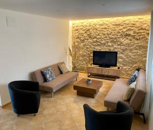 a living room with couches and a flat screen tv at Casa Pastor, Delta del Ebro in El Lligallo del Gànguil