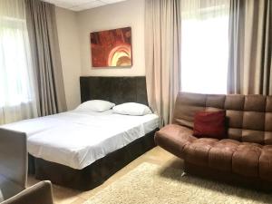 1 dormitorio con 1 cama y 1 sofá en Valencia Mini Hotel, en Khabarovsk
