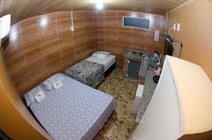Habitación pequeña con 2 camas y lavamanos en Pousada Família Flores, en Penha