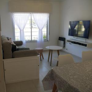 een woonkamer met een bank, een tv en een tafel bij Andoli 2 in Santa Rosa