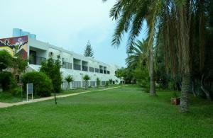 um edifício com palmeiras em frente a um parque em Kkaras Hotel 3 Star em Ayia Napa