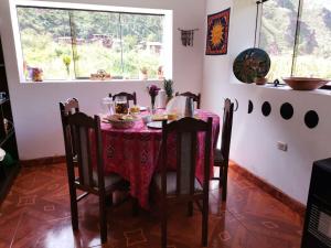 a dining room with a table and chairs and a window at MANCHITAS WASI in Pisac