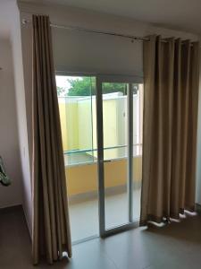 eine offene Glastür mit Vorhängen in einem Zimmer in der Unterkunft Apartamento Beira-Mar, Paraíso dos Pataxós. in Porto Seguro