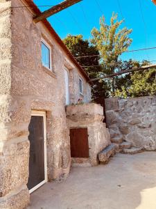 um edifício de pedra com uma porta e uma garagem em Casa de Ovil em Baião