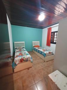two beds in a room with blue walls at Casa Morada da Praia in Boracéia