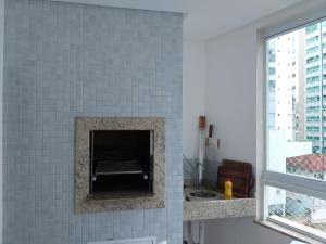 a bathroom with a fireplace in a blue tiled wall at Apto alto padrão in Balneário Camboriú