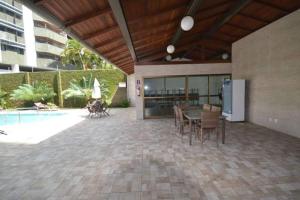 a patio with a table and chairs and a pool at Aptº Espinheiro in Recife