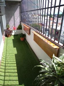 un balcón con un suelo verde con plantas. en Amplio dpto en el centro de Salta. en Salta