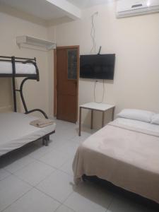 1 dormitorio con 2 camas y TV de pantalla plana en Hotel 678 en Boa Vista