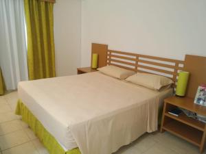 ein Schlafzimmer mit einem großen weißen Bett und einem Tisch in der Unterkunft Hotel Apartamento Giardino - Rio Quente 433-P in Rio Quente