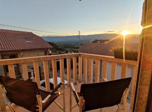 a balcony with two chairs and a view of a city at Zimão Garden House in Vila Real